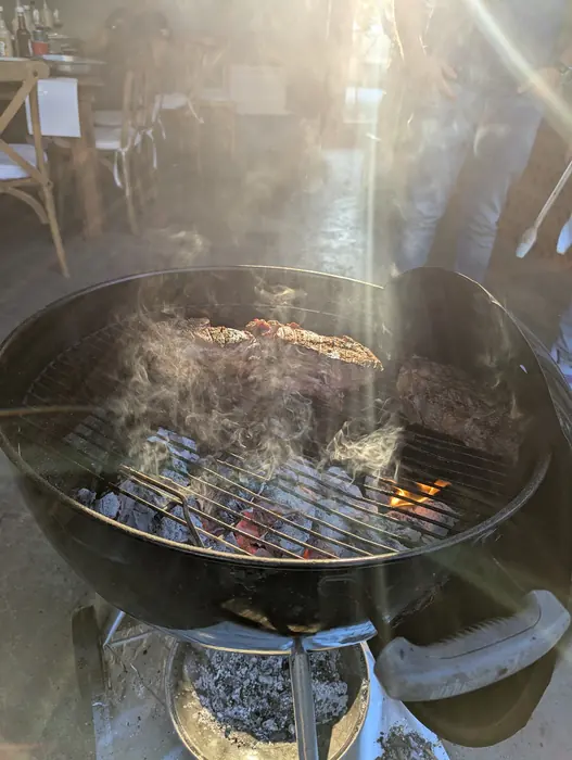 Carne asándose con luz del sol entre el humo