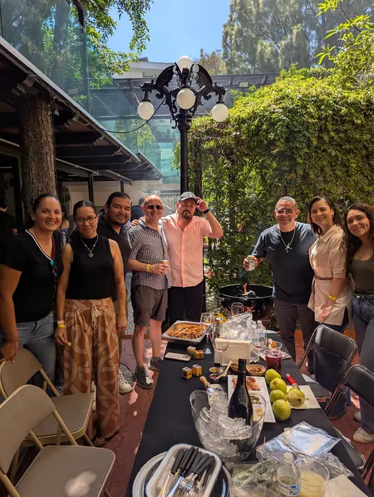 Grupo posando junto al asador en una terraza