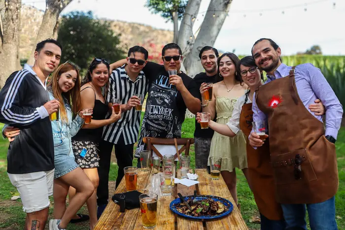 Grupo de amigos con cervezas junto al asador