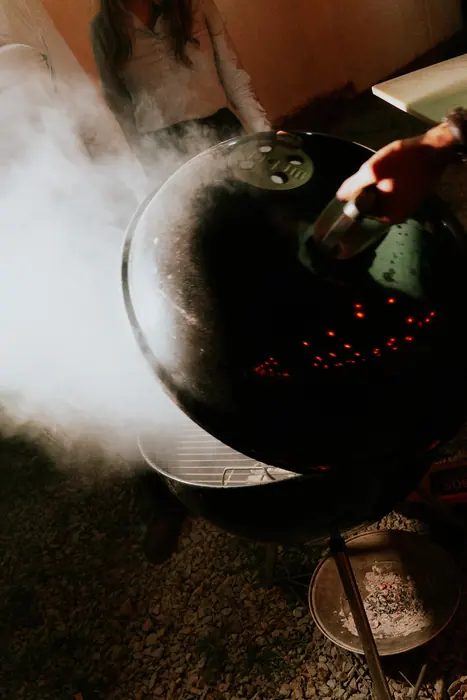 Humo saliendo del asador al levantar la tapa