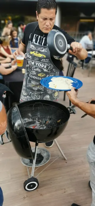 Maestro parrillero sirviendo junto al asador