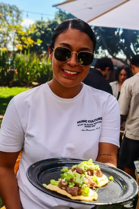 Invitada sonriendo con un plato recién servido